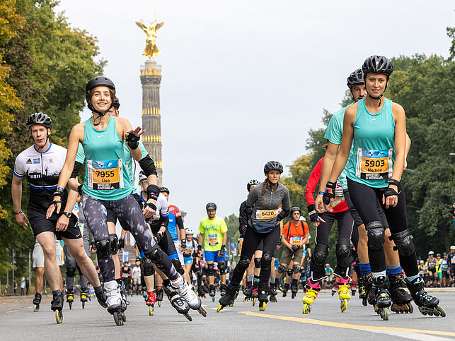 Many inline skaters ride joyfully along the wide roadway, behind them you can see the Victory Column.